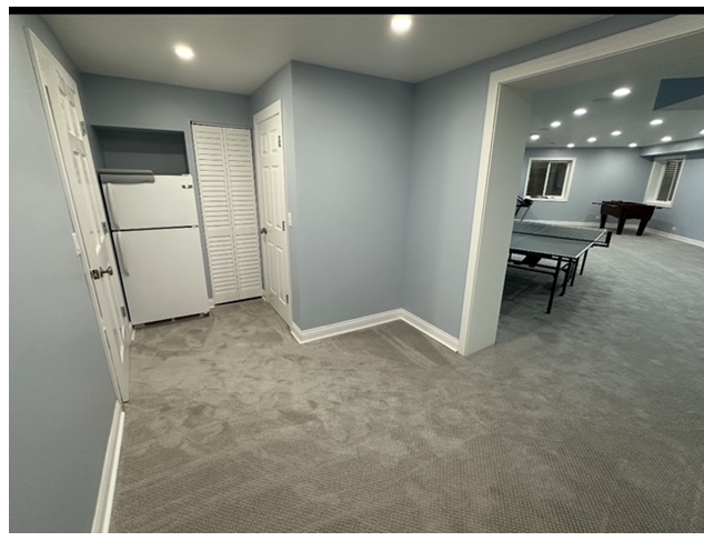 A room with a refrigerator and a table in it