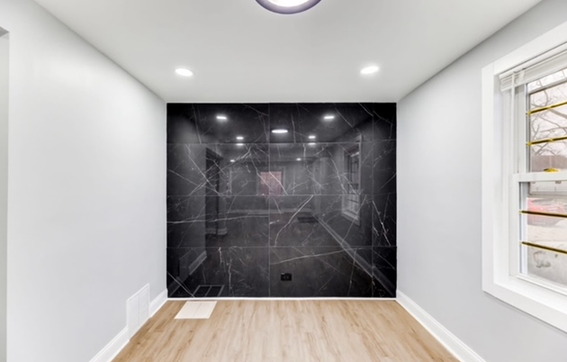 An empty room with a black wall and a window