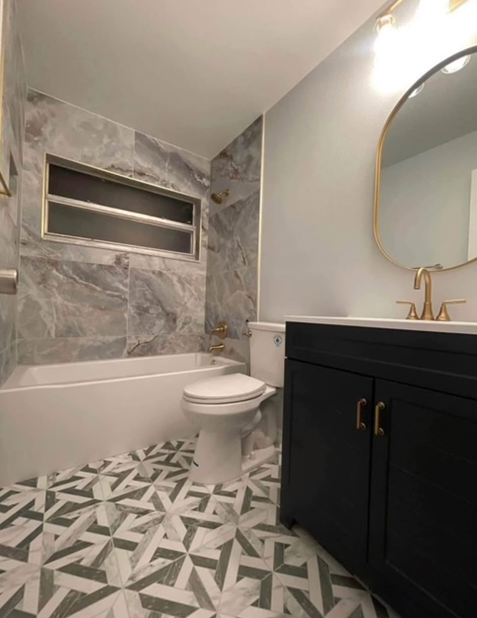 A bathroom with a toilet , sink , bathtub and mirror.