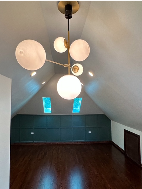 An empty room with a chandelier hanging from the ceiling
