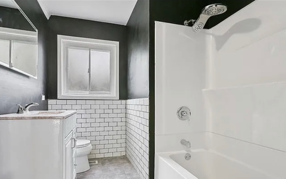 A bathroom with a toilet , sink , and bathtub.