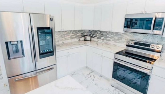A kitchen with stainless steel appliances and white cabinets.