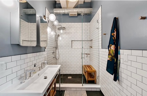 A bathroom with white tiles and a walk in shower.
