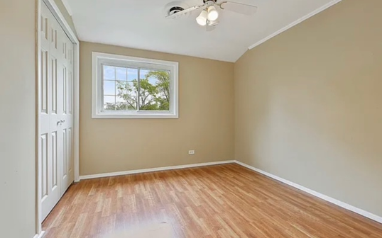 An empty room with hardwood floors and a window.