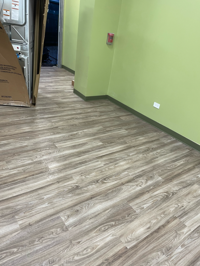 A hallway with a wooden floor and green walls.