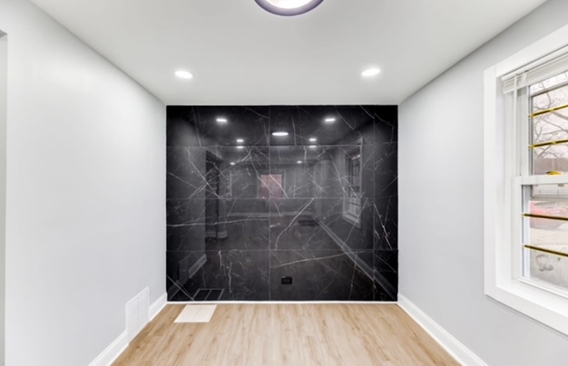 An empty room with a black wall and a window