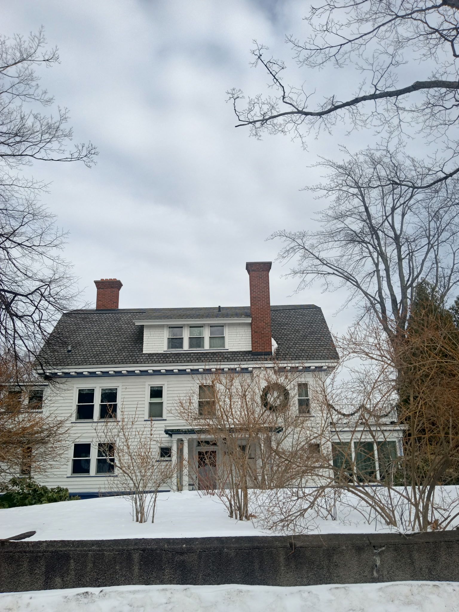A large white house with a wreath on the front door.