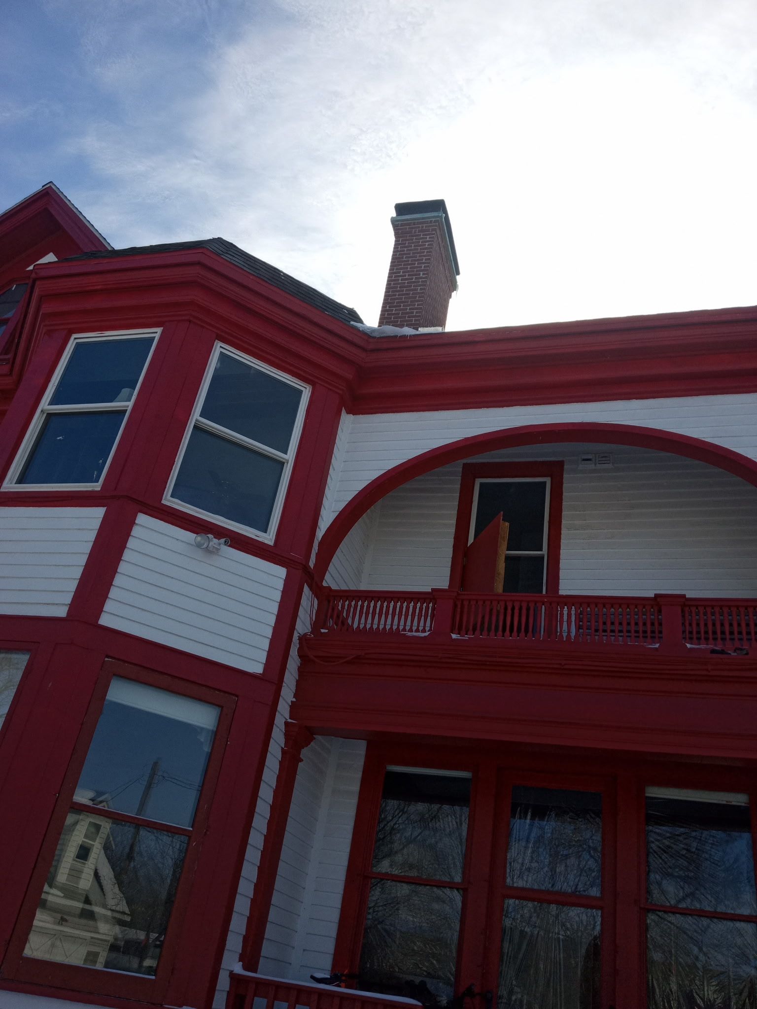 A red and white house with a chimney on the roof.