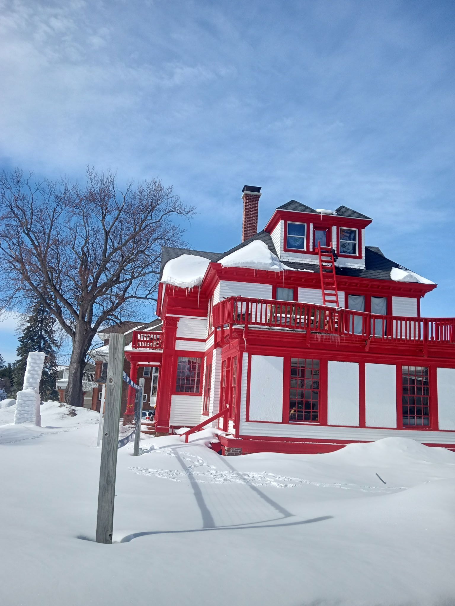 A red and white house is covered in snow.