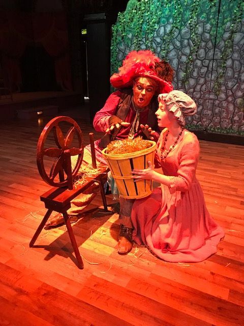 A man and a woman are sitting on a stage holding baskets.