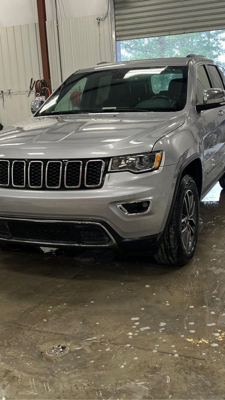 Silver Jeep SUV parked indoors on a wet concrete floor