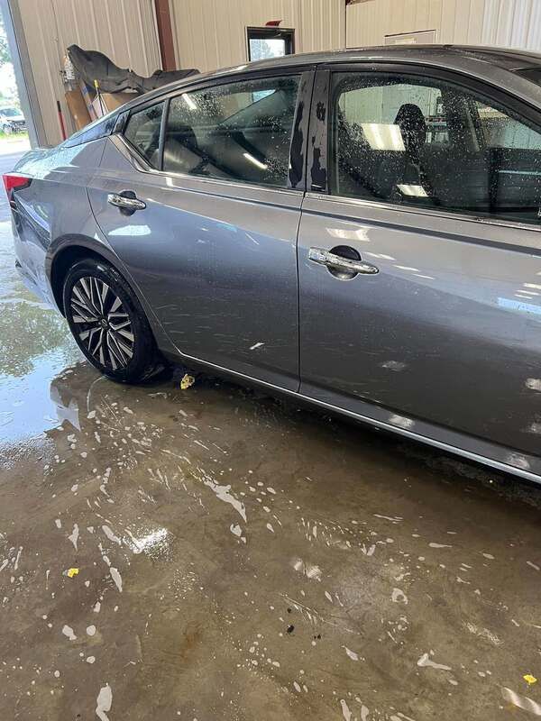Silver sedan parked in a flooded garage, with water covering the concrete floor
