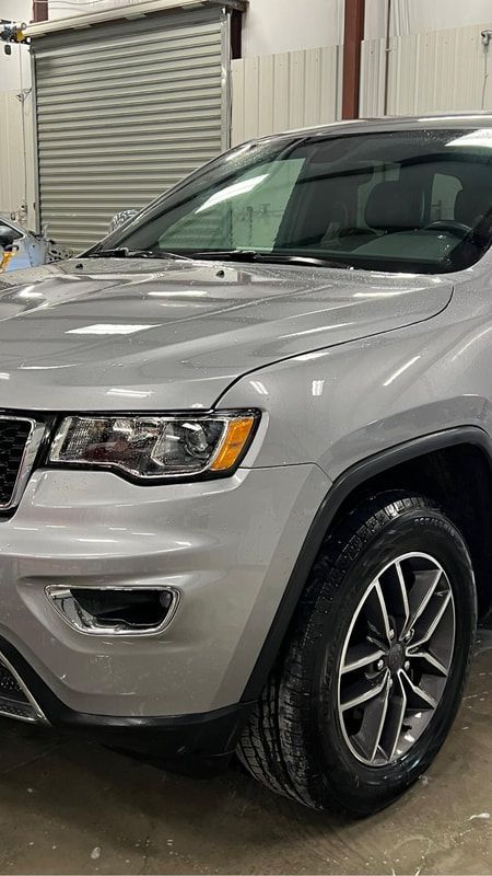 Silver SUV parked indoors near a garage door, front-left view