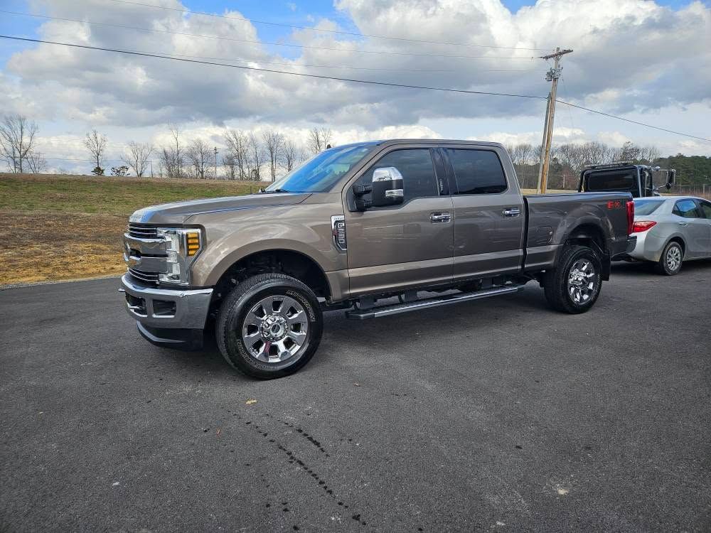 Gray pickup truck parked on a roadside under a cloudy sky
