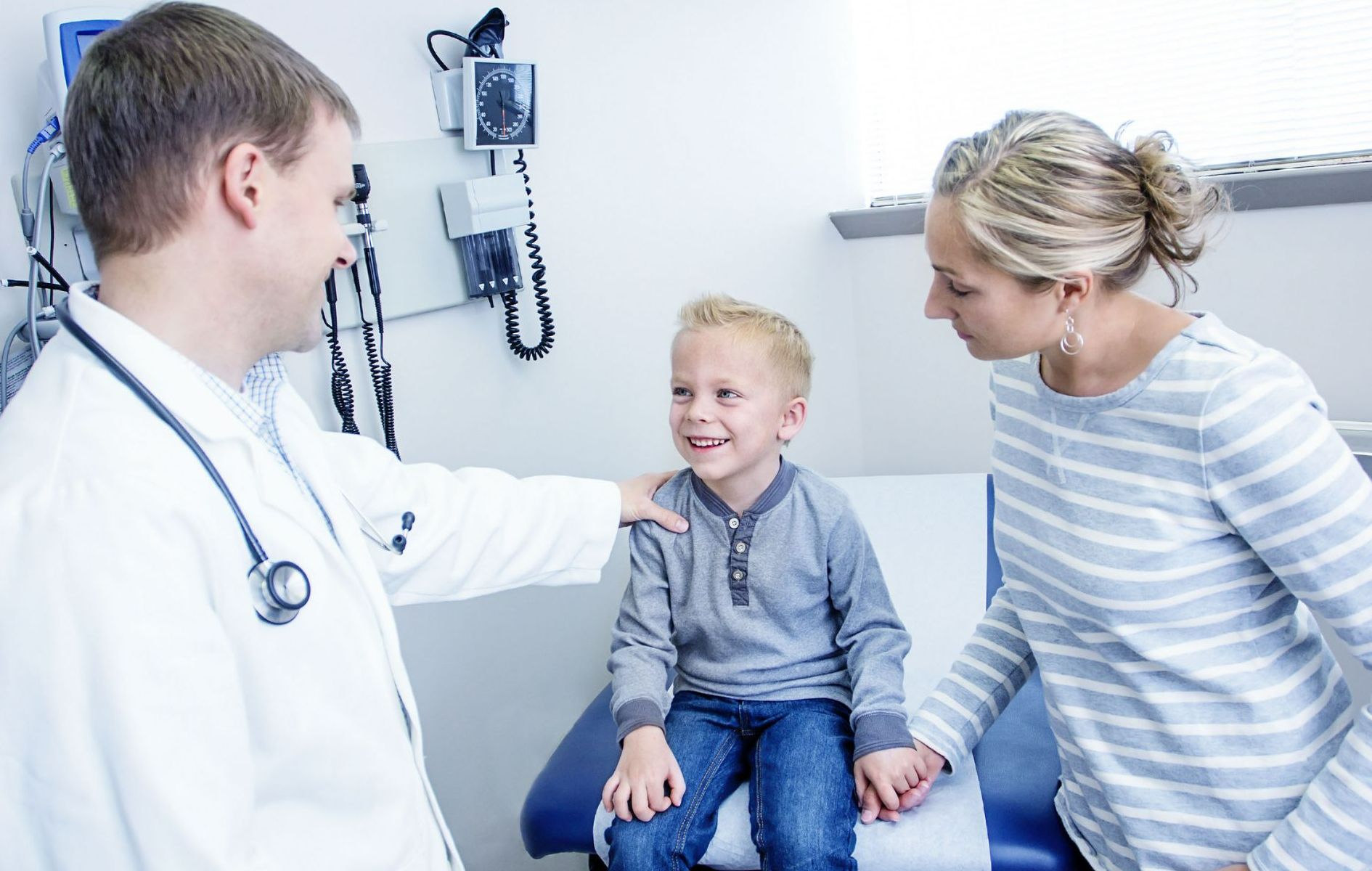 A doctor talks to a little boy and his mother