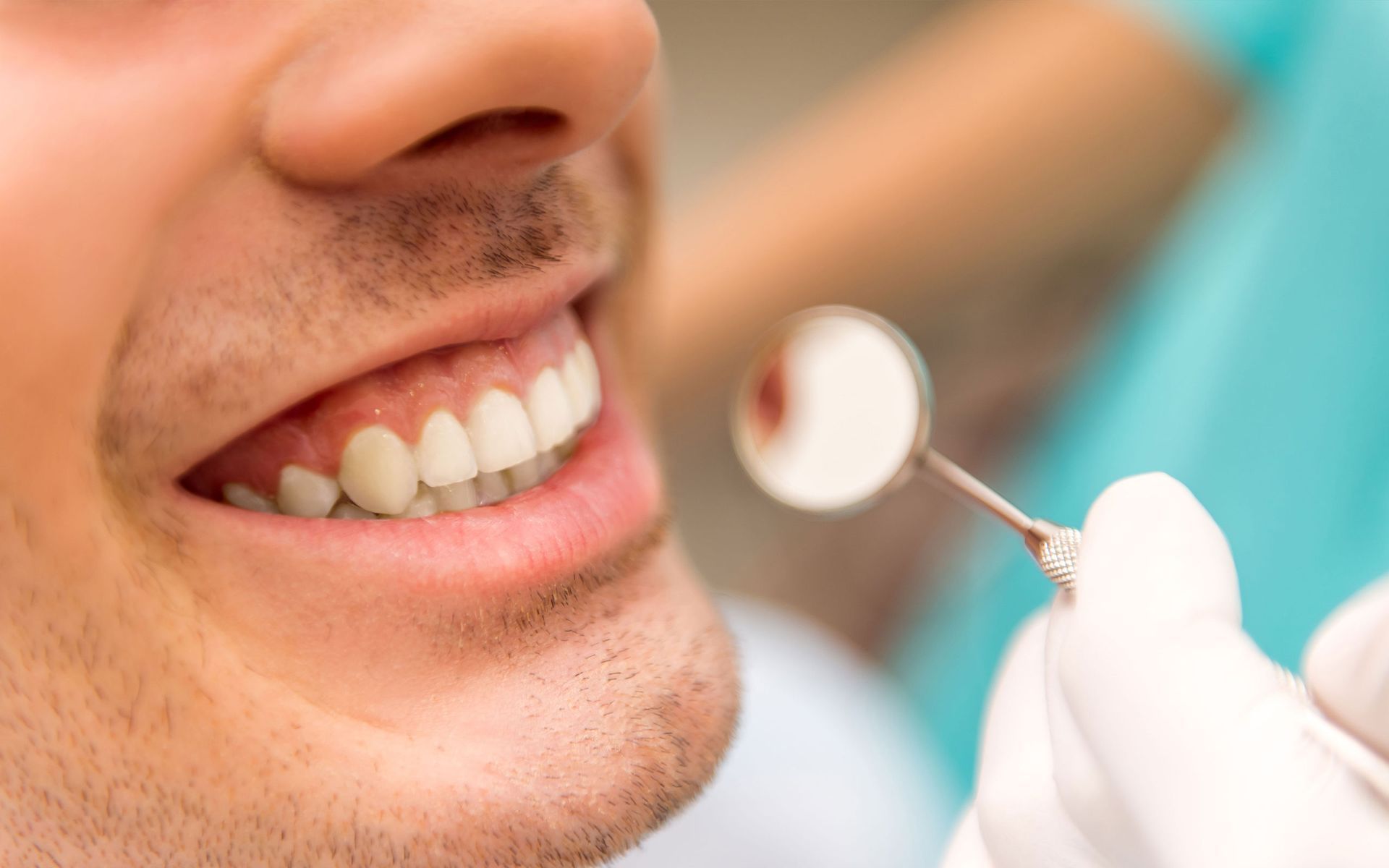 a man is getting his teeth examined by a dentist