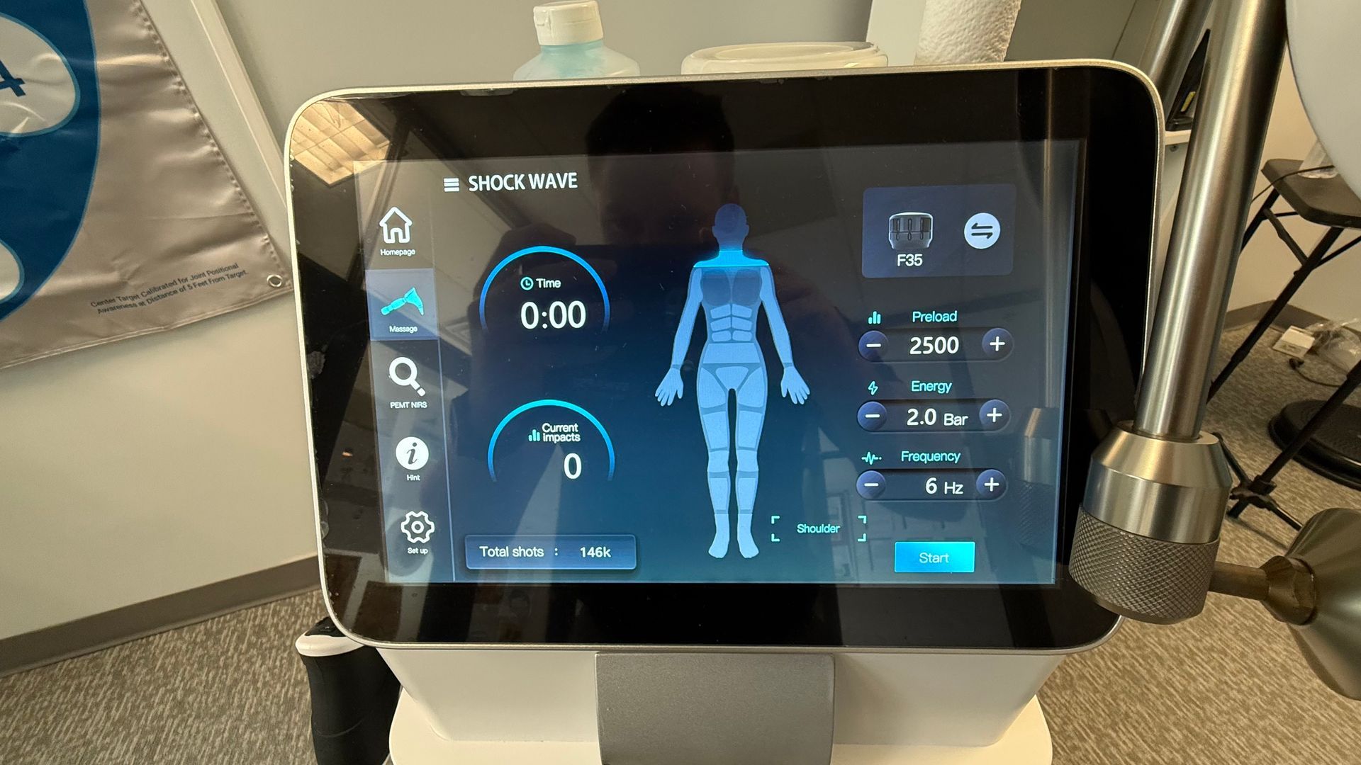 A touchscreen display showing a human figure and various numerical readouts, likely part of a medical or therapeutic device.