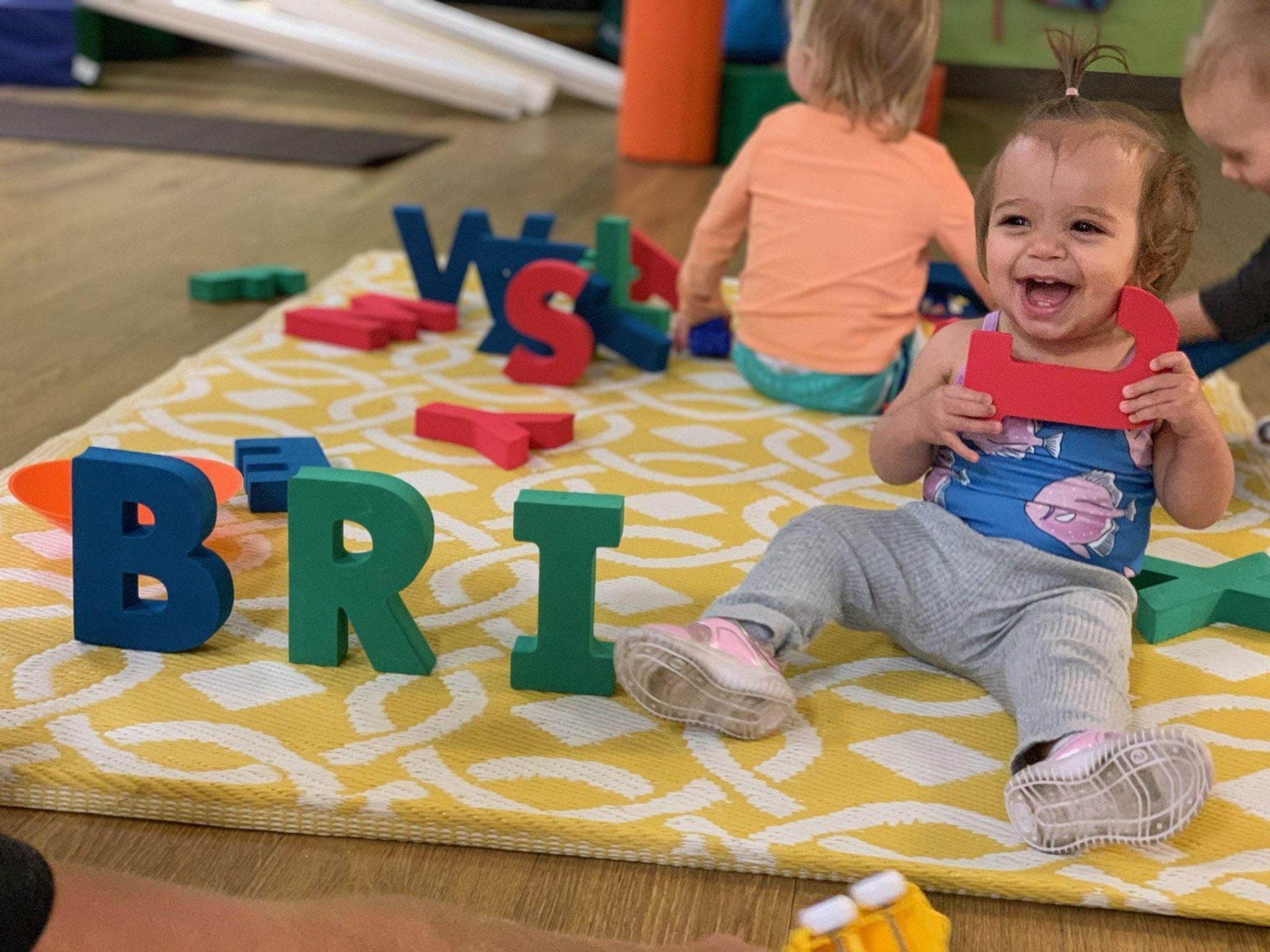 Child laughing, holding letter 