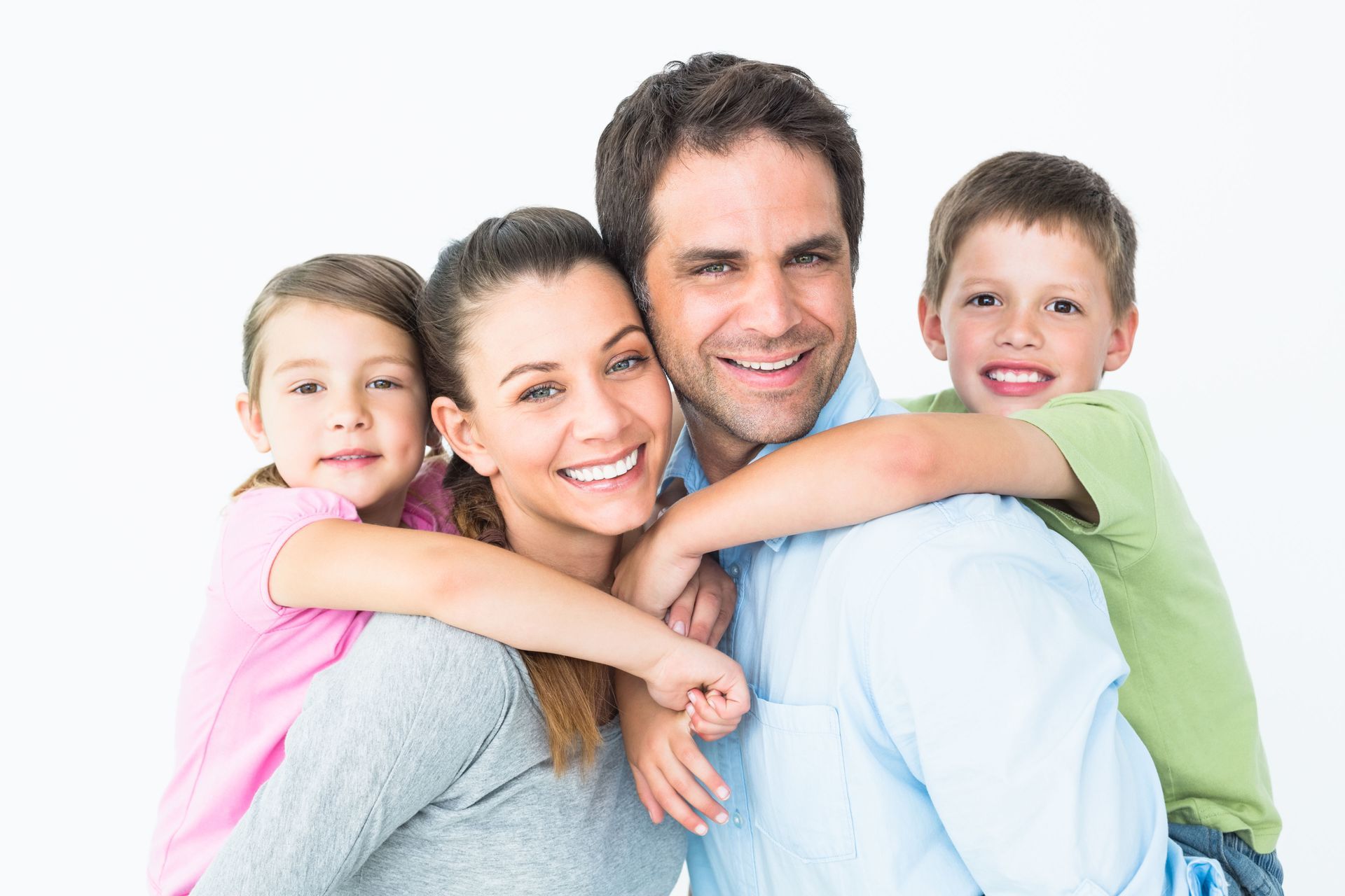 A family is posing for a picture together and smiling for the camera.