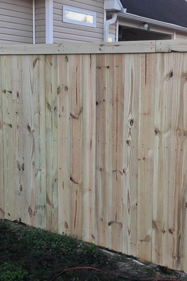 A wooden fence is sitting in front of a house.