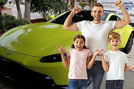 A smiling person and two children celebrate in front of a bright lime green sports car parked in a driveway.