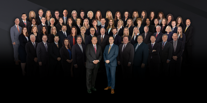 A large group of people in suits and ties are posing for a picture.