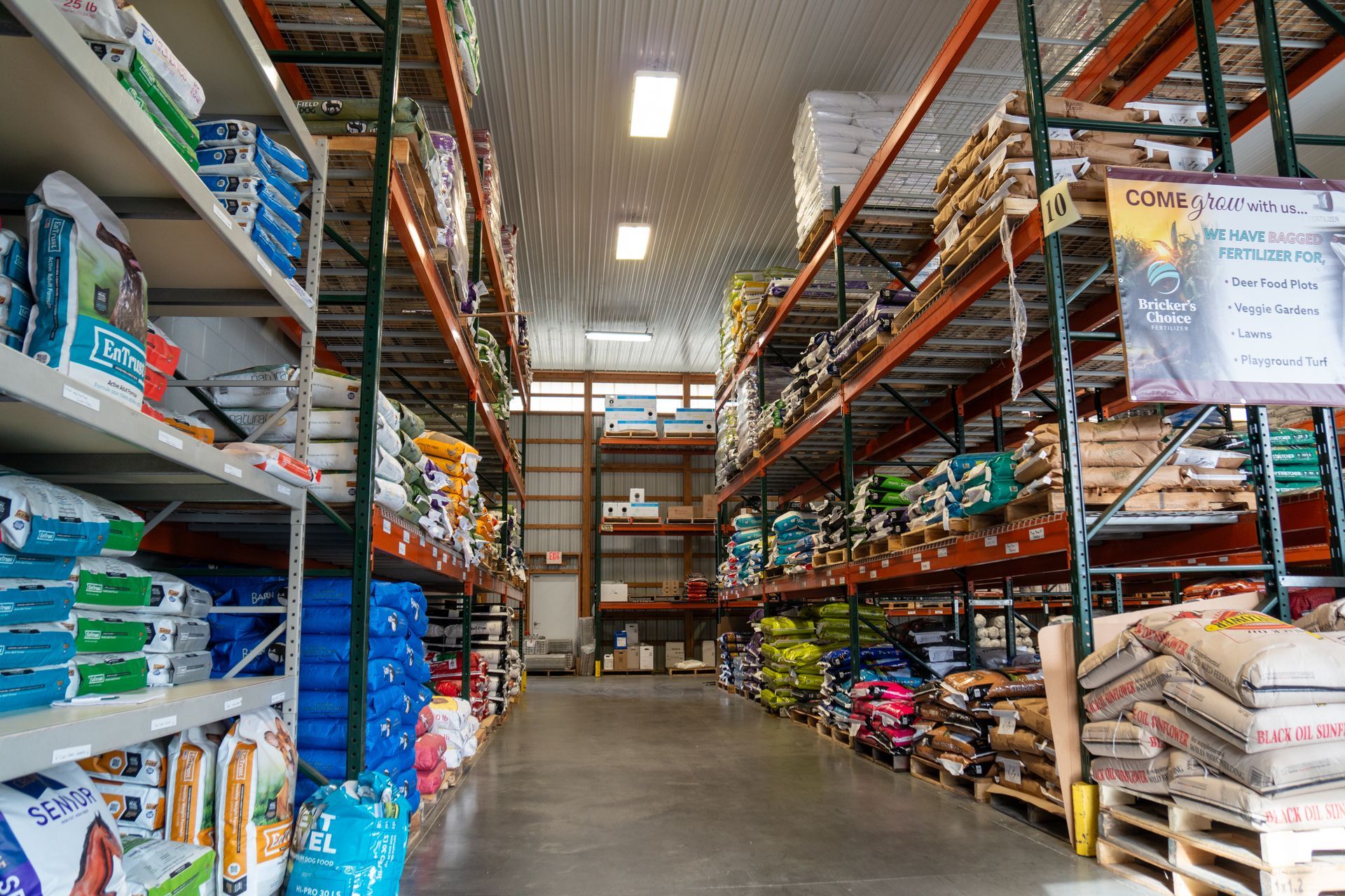 Shelves stocked with bags of animal feed inside a warehouse.