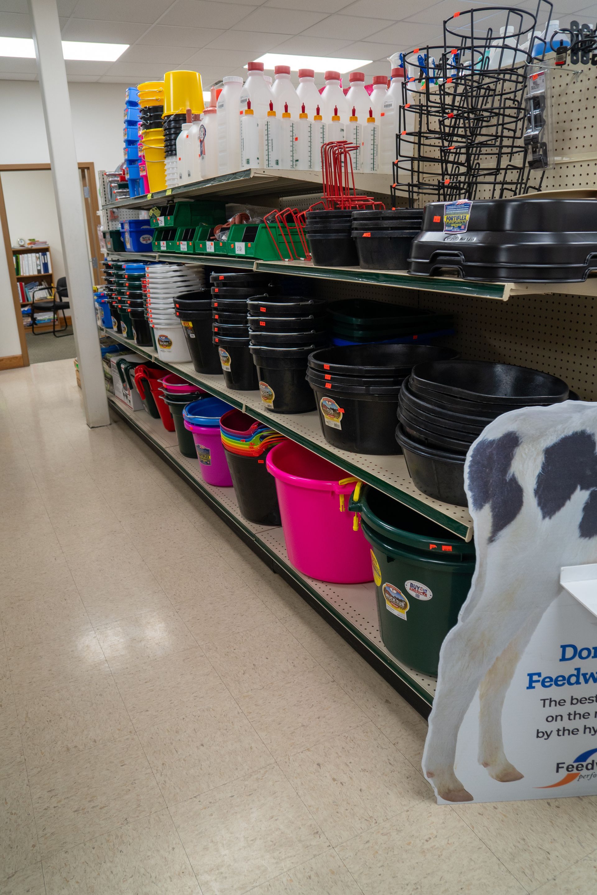 Shelves stocked with various colorful buckets in a store.