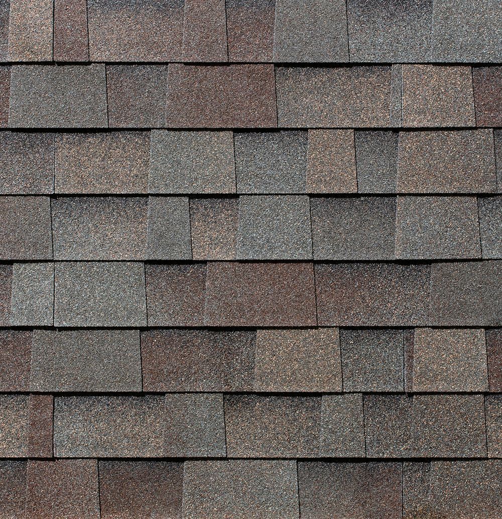 Overlapping brown and gray asphalt roof shingles.
