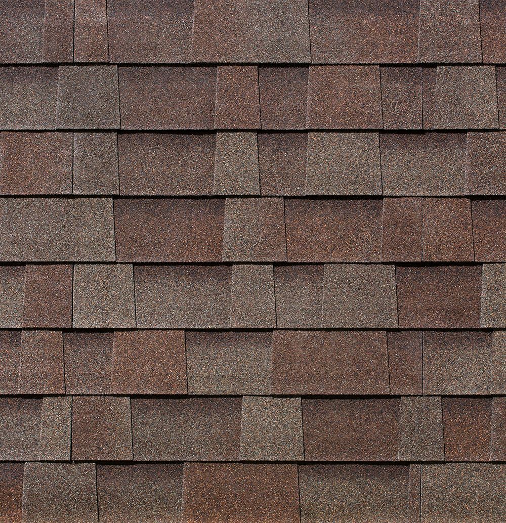 Brown and tan asphalt roof shingles are arranged in rows.