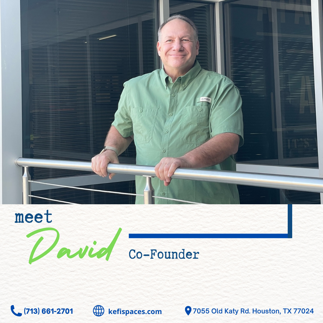 David, co-founder of keftspaces, stands on a balcony. He's wearing green and smiling.