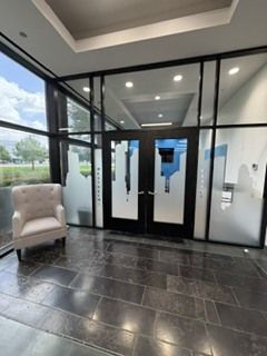 Modern conference room with long table, black chairs, blue accent wall, and wall-mounted TV