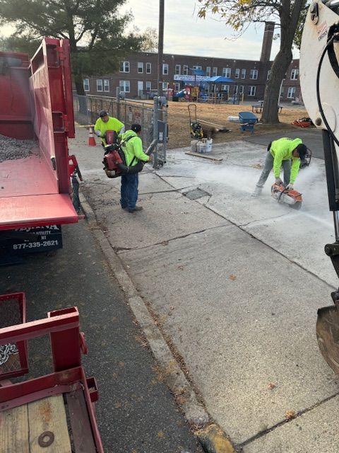 A group of construction workers are working on a sidewalk