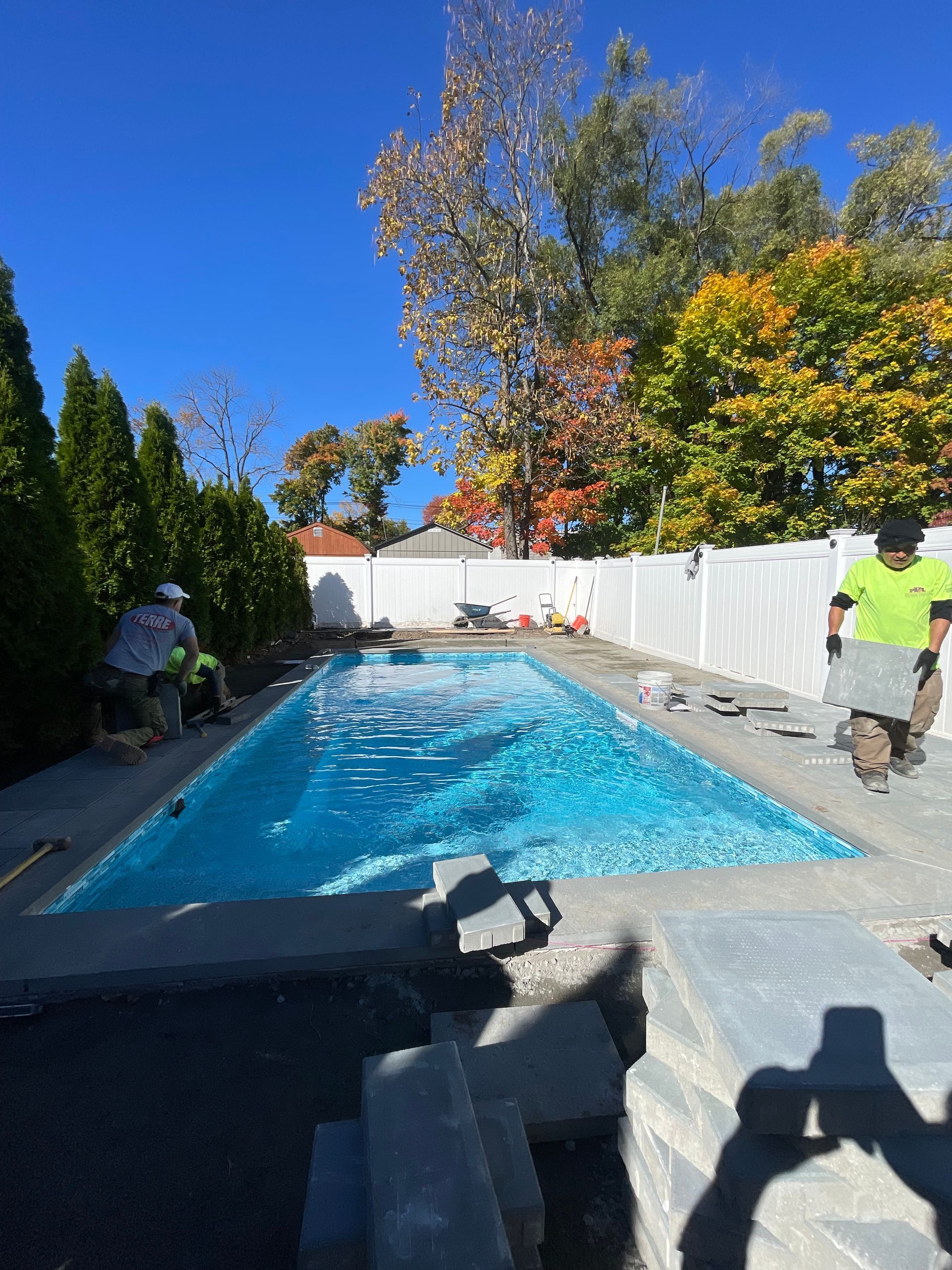 A large swimming pool is being built in a backyard