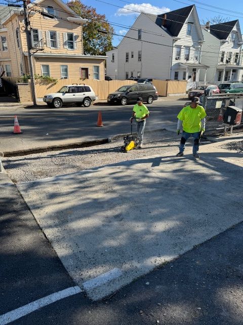 A couple of men are standing on the side of a road.