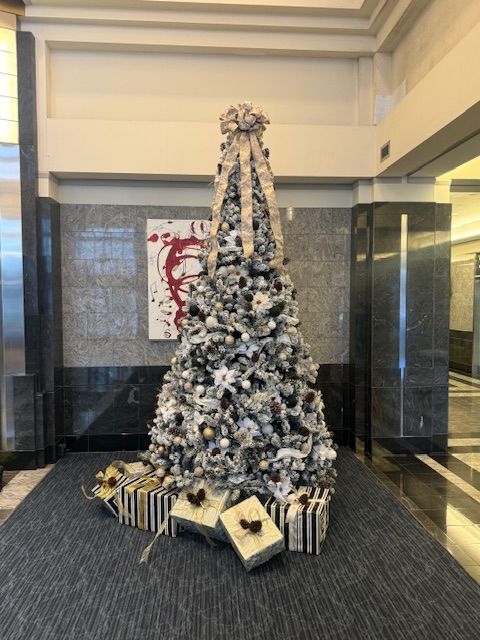 A large white christmas tree with gifts underneath it