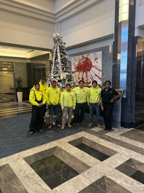 A group of people standing in front of a christmas tree