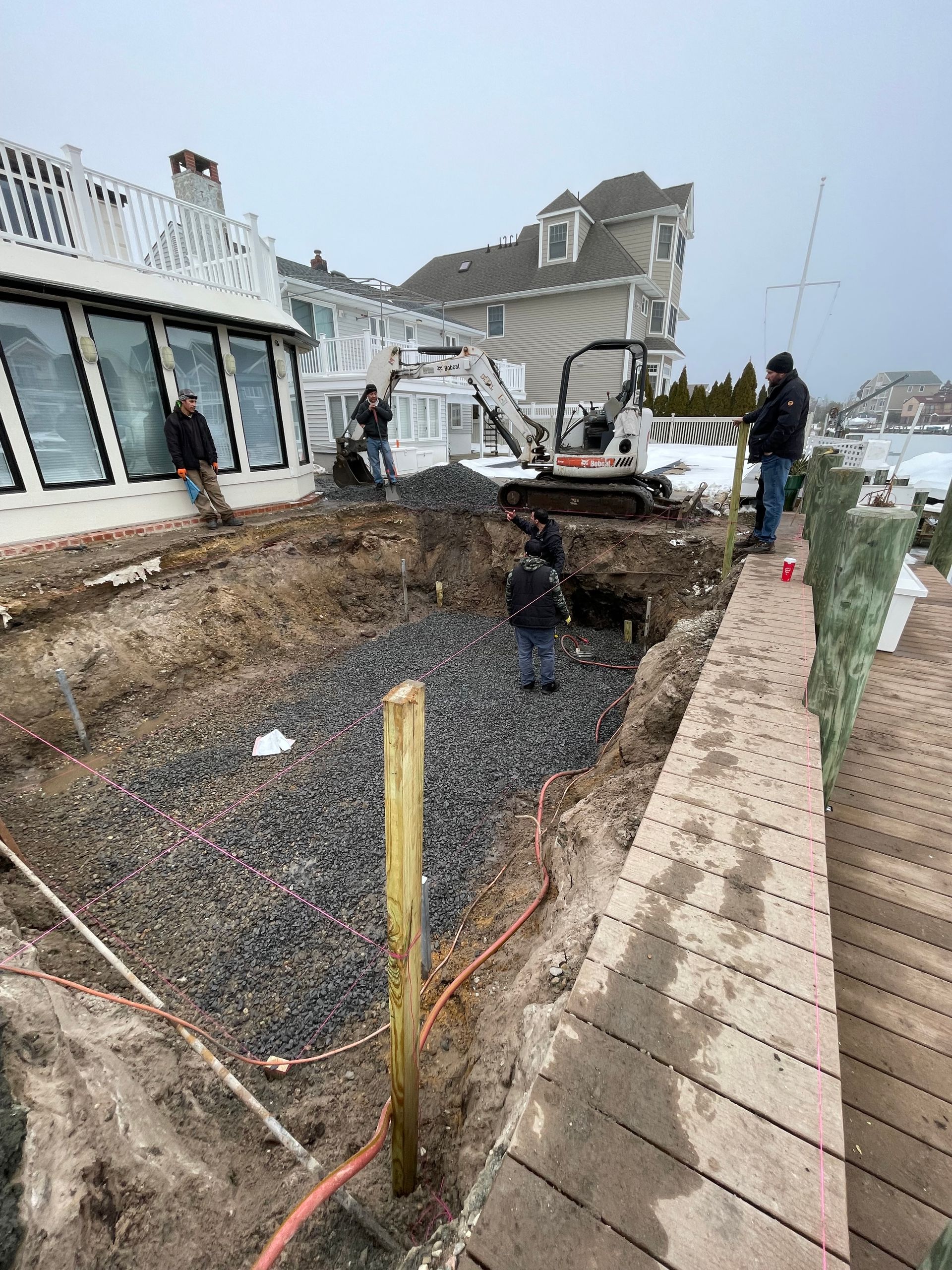 A group of people are working on a construction site next to a house.