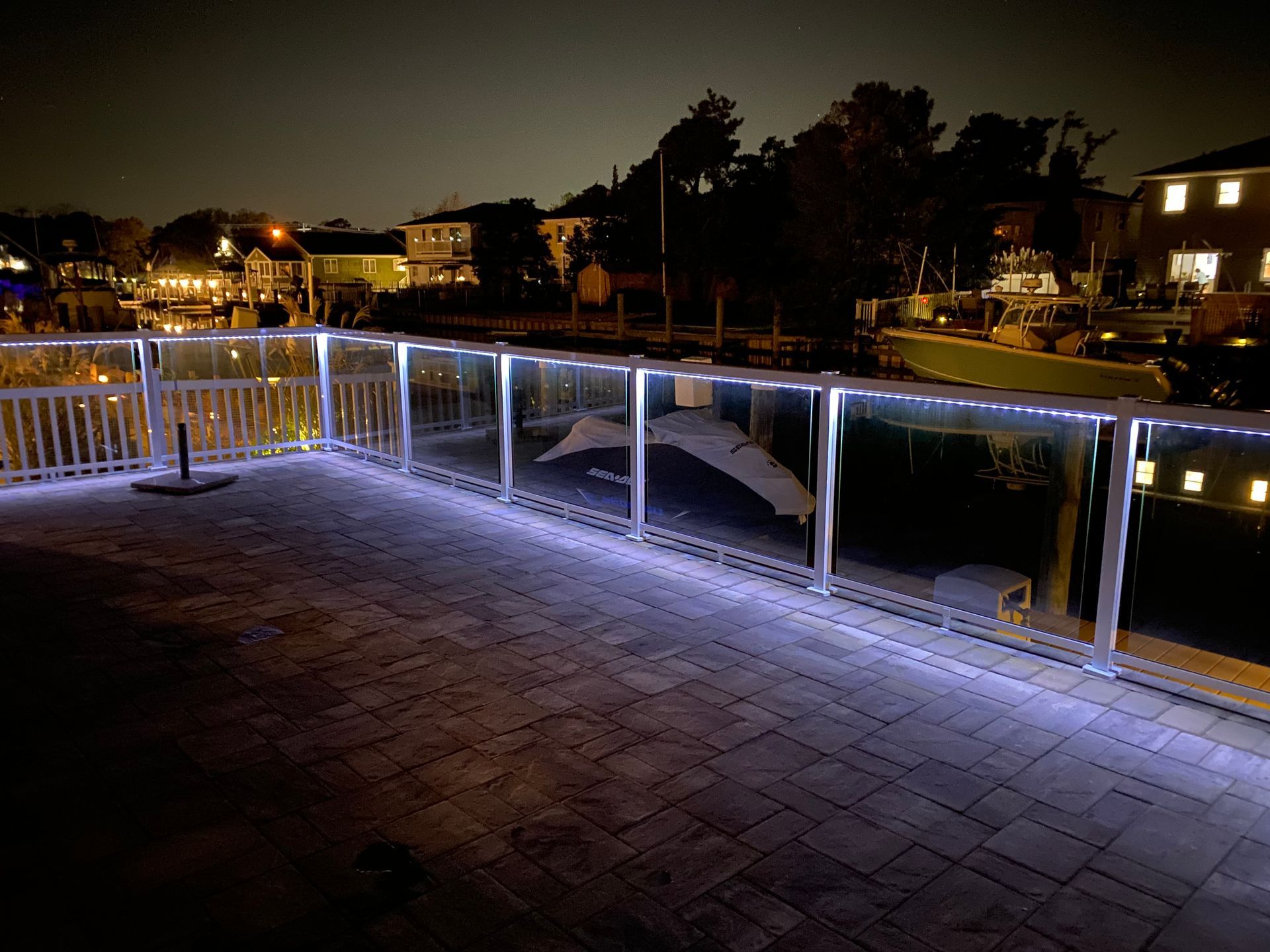 A balcony with a fence and lights on it at night