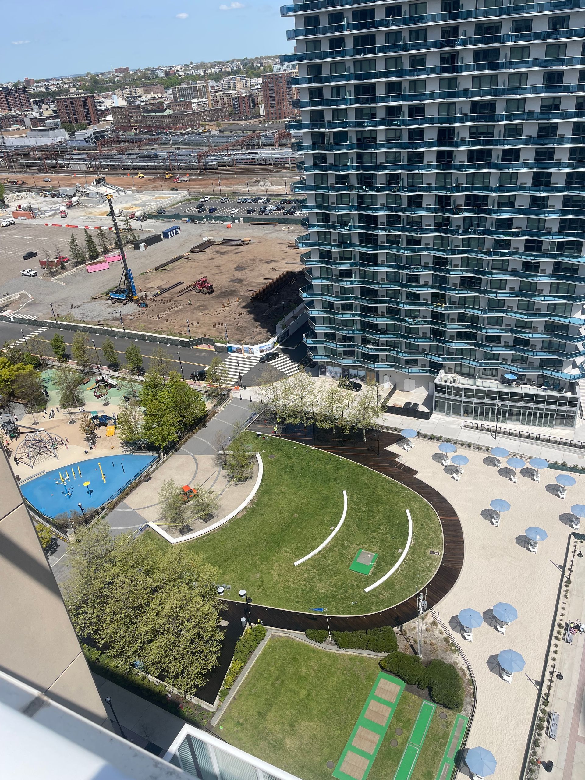 An aerial view of a park with a large building in the background