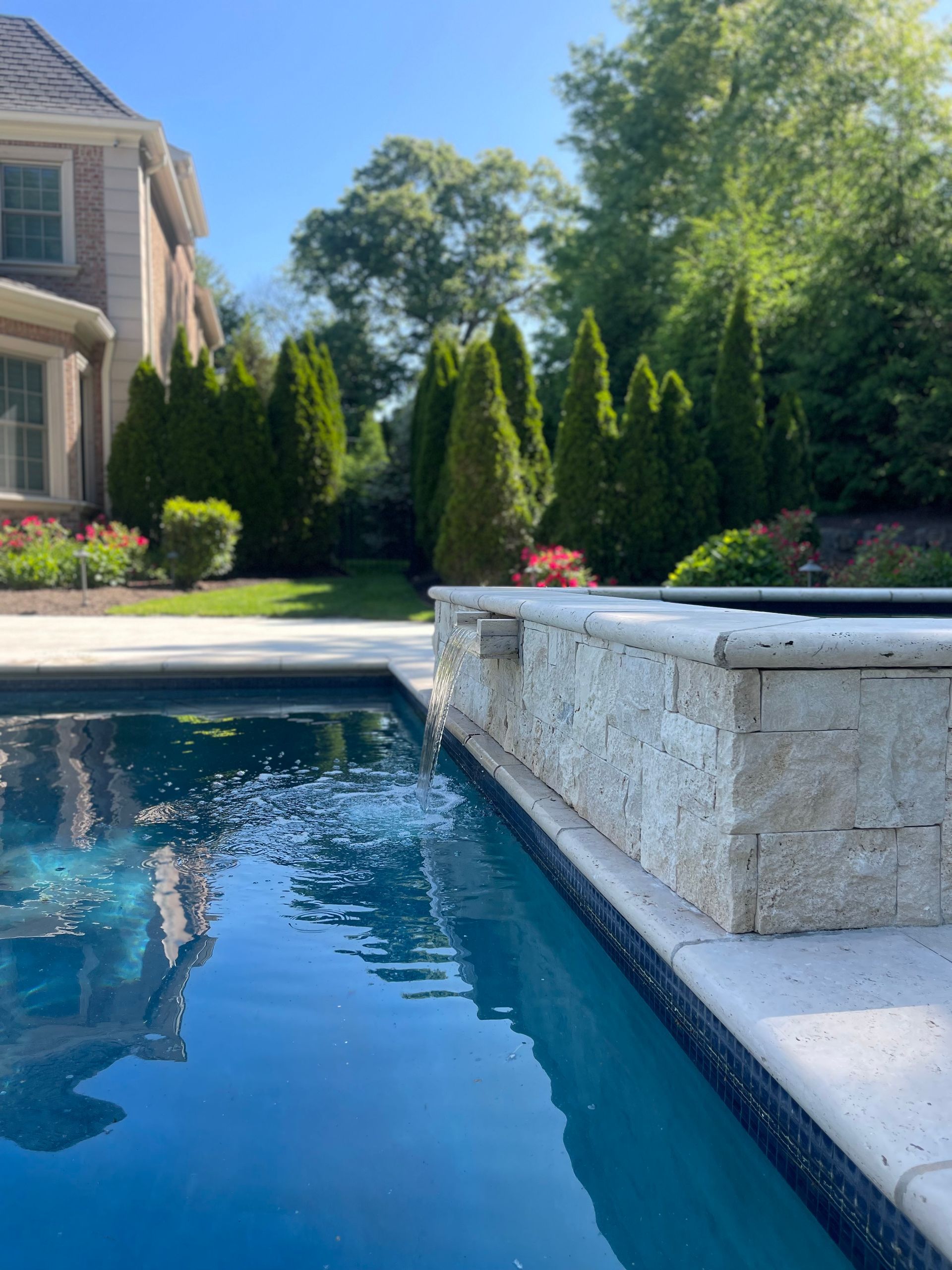 A large swimming pool with a house in the background