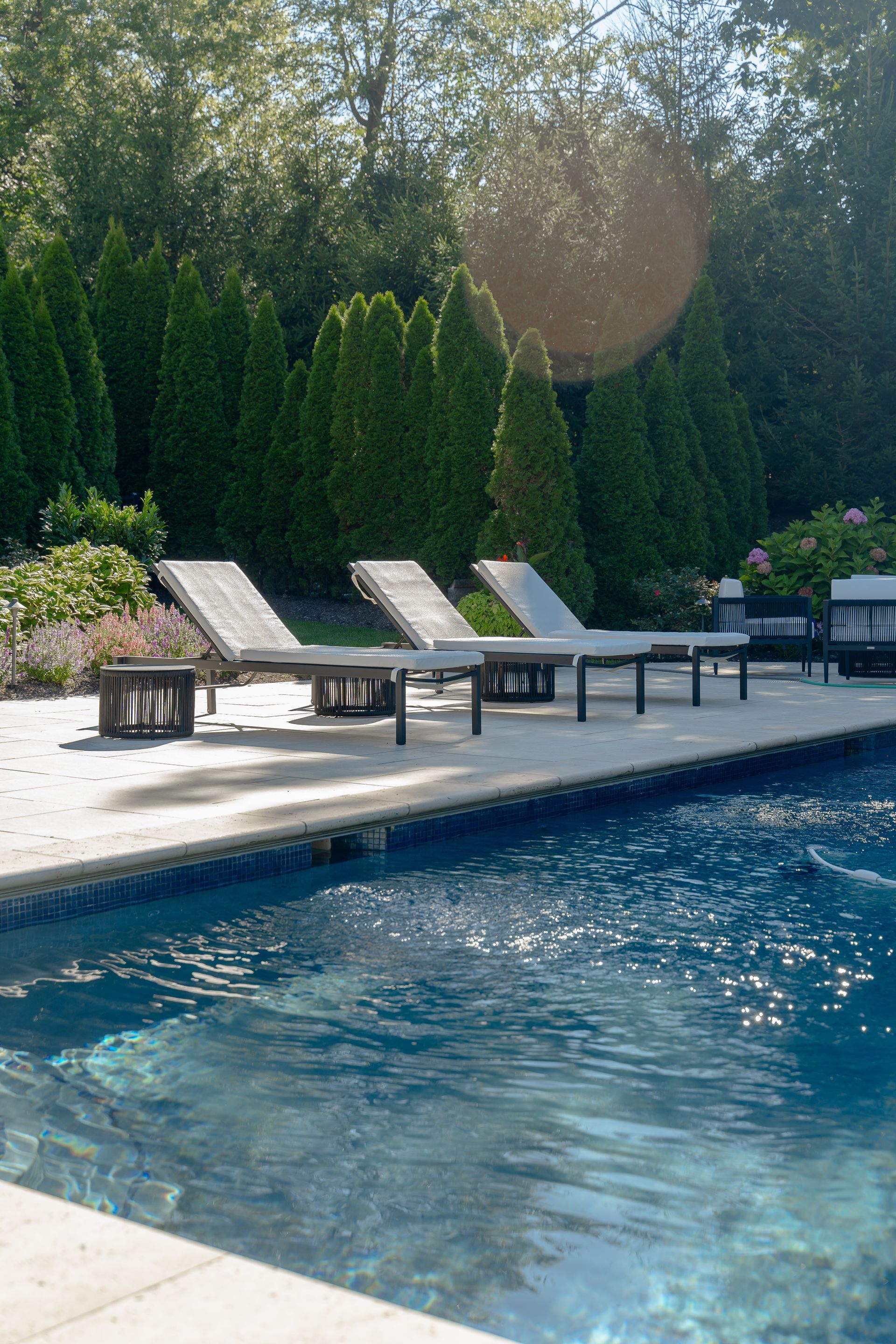 A row of lounge chairs sitting next to a large swimming pool.