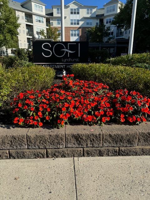 A sign for sgf landlords is surrounded by red flowers