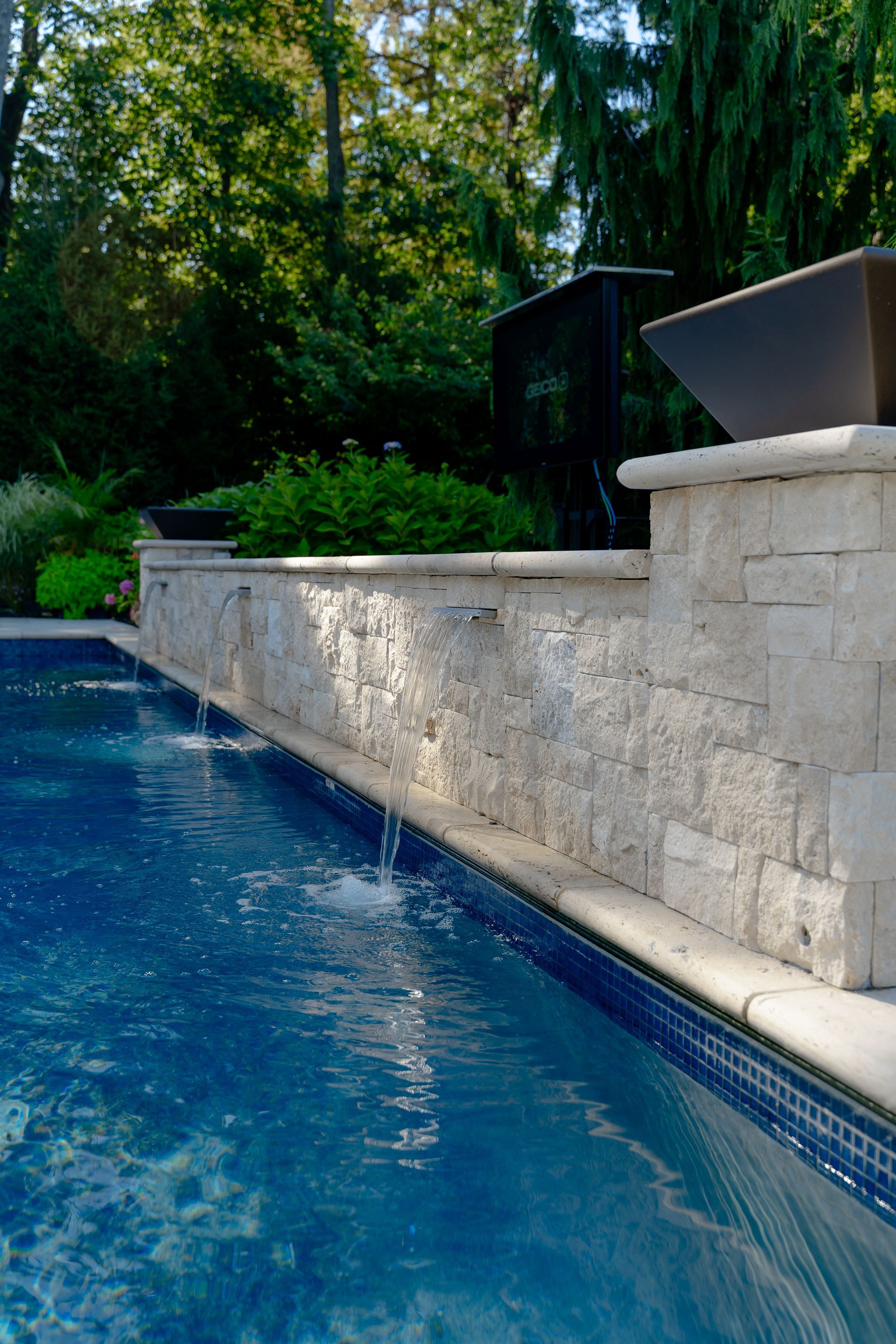 A swimming pool with a waterfall on the side of it
