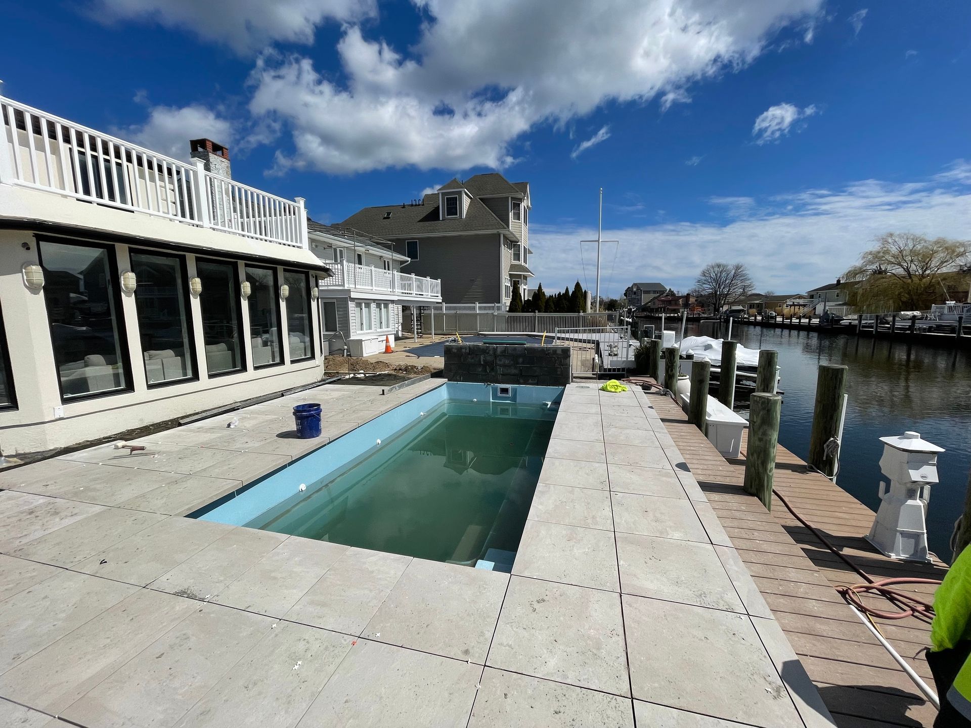 A large swimming pool is being built in the backyard of a house.