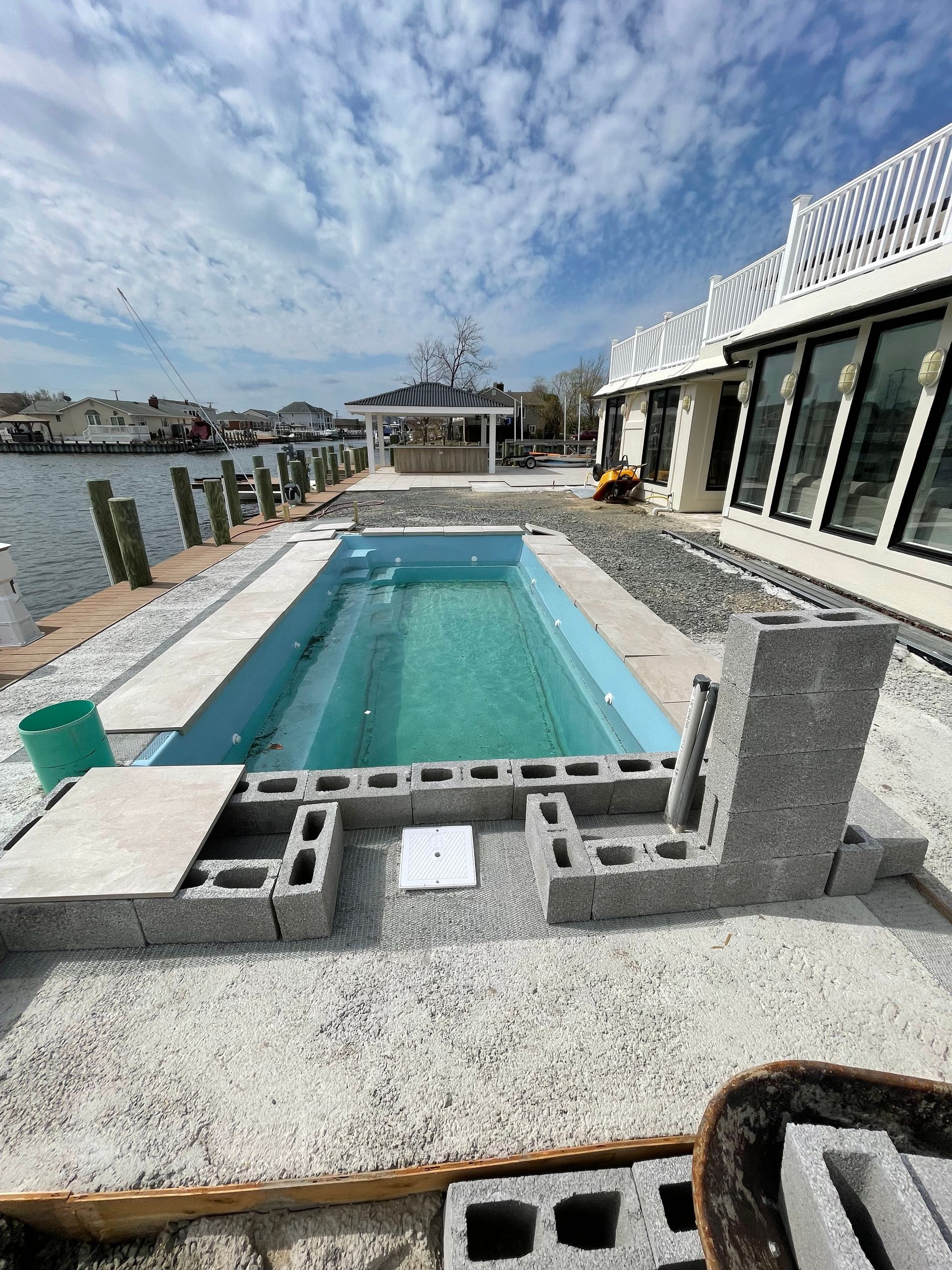 A large swimming pool is being built in the backyard of a house.