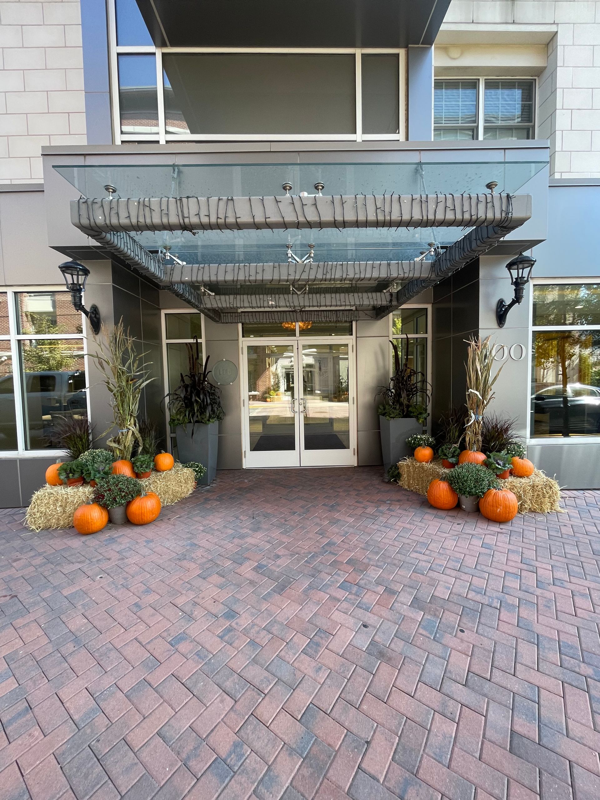 A building with pumpkins and hay bales in front of it