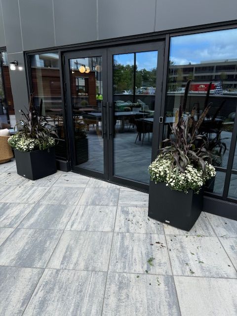A building with a lot of windows and planters in front of it.