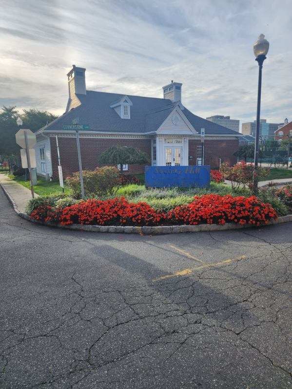 A building with a sign in front of it and flowers in front of it.