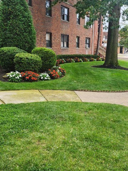 A large brick building with a lush green lawn in front of it.